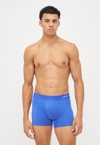 Blaue Baumwollboxershorts mit einem dehnbaren Bund, der mit einem Logo versehen ist. Glatte Textur und körperbetontes Design mit einer Länge bis zur Mitte des Oberschenkels.