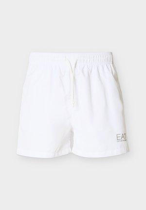 Pantaloncini da bagno bianchi con vita elastica, cordino e un logo discreto in grigio chiaro sull'angolo inferiore destro. Materiale liscio e leggero.