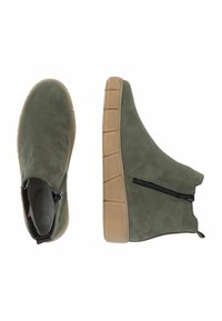 Botas de tobillo de ante verde con un cierre lateral y una suela de goma beige con un patrón texturizado para mayor agarre. Silueta limpia y moderna.