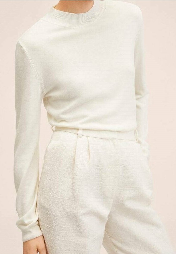 Maglione bianco a maniche lunghe con scollo a girocollo, abbinato a pantaloni tapered color crema chiaro con pieghe e tessuto strutturato.