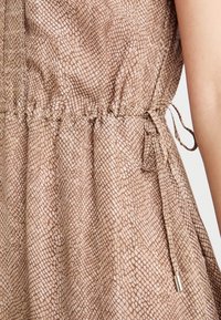 Rjava obleka s potiskom, ki vsebuje teksturiran vzorec kače, zložen pas z nastavljivo vrvico in kovinskim detajlom na vezavi.