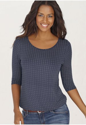 Navyblaue Bluse mit drei Viertelärmeln und einem geometrischen weißen Muster. Hergestellt aus weichem Stoff, mit Rundhalsausschnitt und taillierter Form.