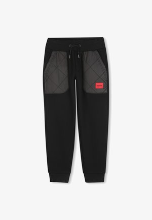 Schwarze Jogginghosen mit gesteppte schwarze Netzstofftaschen, verstellbarem Taillenbund und rotem "HUGO"-Logo, mit gerippten Bündchen an den Knöcheln.