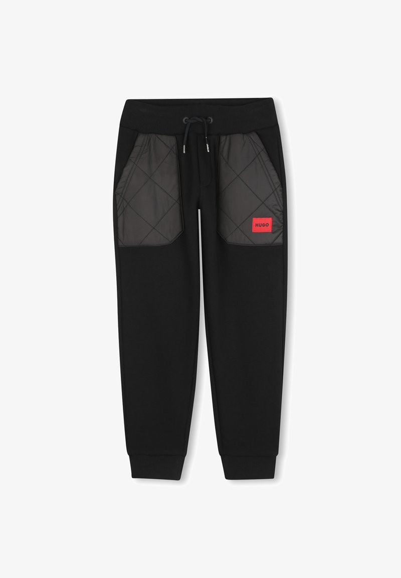 Zwarte joggingbroek met doorgestikte zwarte meshzakken, verstelbare tailleband en rood "HUGO" logo, met geribbelde boorden bij de enkels.