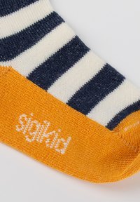 Gestreifte Socke in Marineblau und Creme mit einem orangen Bund. Enthält den Text "siglAid" in Weiß, aus gestricktem Textil hergestellt.