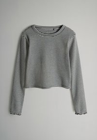 Czarny i biały pasiasty, długi rękaw, krótki top z okrągłym dekoltem i falbaniastym dołem. Wykonany z materiału prążkowanego, charakteryzuje się dopasowanym fasonem.