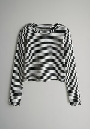 Mustvalge triibuline pika varrukaga lühike topp ümarate kaelustega ja lainelise äärega. Valmistatud ribakanga materjalist, omab vormitud disaini.