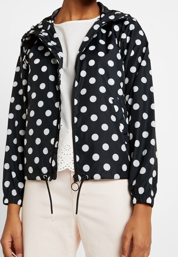 Černá bunda s kapucí s bílými puntíky, elastickými manžetami, otevřeným předním dílem a stahovací šňůrkou v pase. Hladký, lehký materiál.