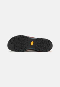 Suola in gomma nera con motivo a questo esagonale e logo Vibram. Presenta una tomaia in tessuto colorato con cuciture e dettagli visibili.
