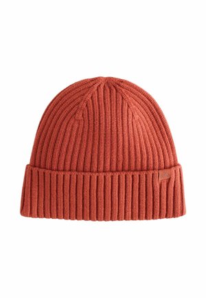 Bonnet en laine tricotée couleur rouille avec des côtes verticales, un revers, et une petite étiquette en cuir de marque sur le côté.