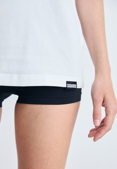 White cotton t-shirt with a black tag featuring "DSQUARED2 UNDERWEAR," paired with black fitted shorts. Simple design, short sleeves.