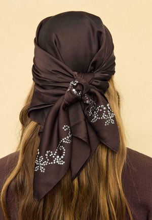 Cheveux longs châtain clair avec un foulard en satin brun foncé noué à l'arrière, décoré de clous argentés formant des motifs floraux.