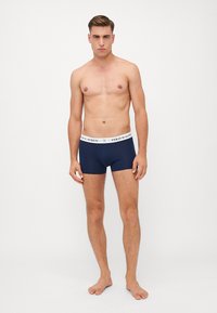 Sötétkék boxer alsónadrág rugalmas anyagból, fehér derékszíjjal, amelyen a "POLO RALPH LAUREN" logó kontrasztos szöveggel szerepel.