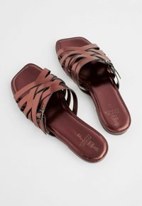Bordeaux slip-on sandaler med firkantet tå, der har vævede stropper og en blank finish. SÅlen er glat med subtile brandingdetaljer.