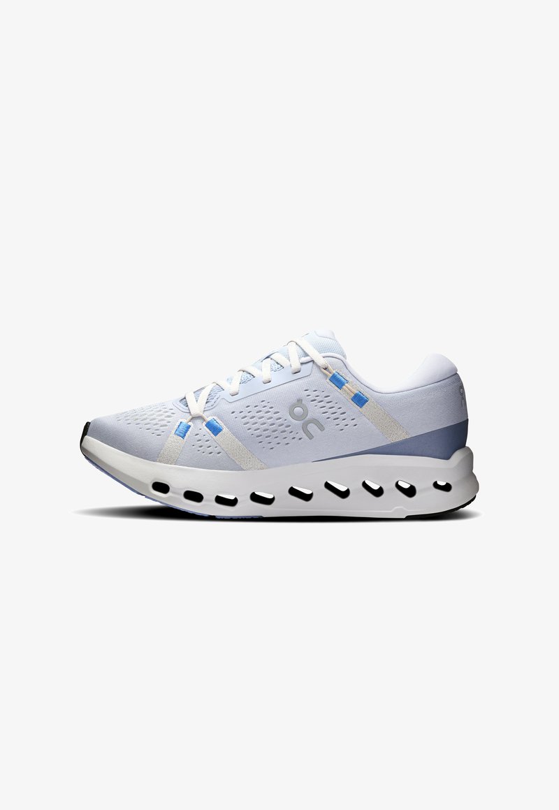 Chaussure de sport bleu clair avec lacets blancs, tige en mesh respirant et semelle rembourrée avec de grandes découpes ovales pour la ventilation.