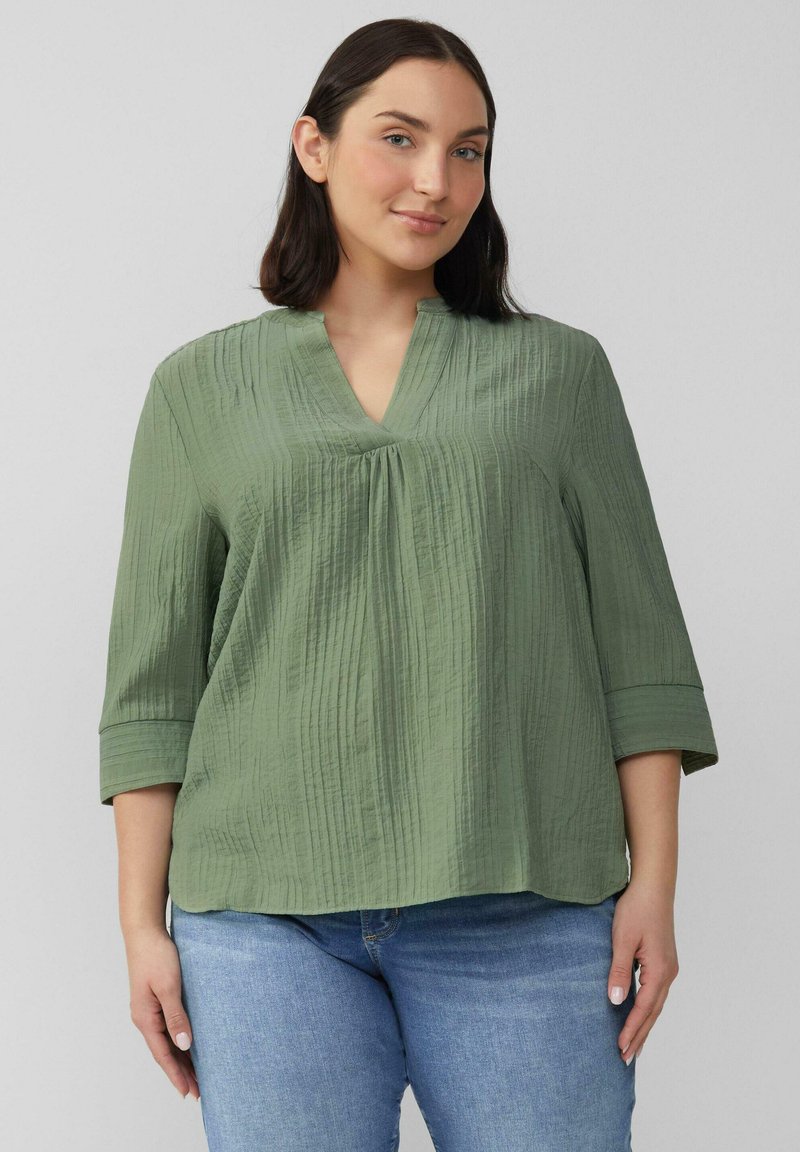 Lichtgroene, gestructureerde blouse met een V-hals en driekwartmouwen. Bevat subtiele verticale strepen en heeft een ontspannen silhouet.