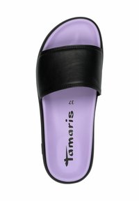 Svart slid sandalett med bred rem, med en mjuk lila innersula och svart yttersula. Logotypen "Tamaris" tryckt i svart på innersulan.