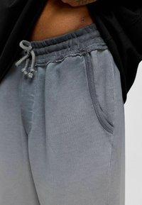Grijze sweatpants met een elastische tailleband met koord, textuurstof, zijzakken en een relaxte pasvorm.