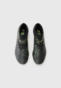 Adidași negri pentru sport, cu textură pe partea superioară, detalii în verde neon, șirete plate și un design ajustat, potrivit pentru performanță.