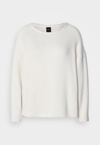 Fehér pulóver puha anyagból, kerek nyakkivágással, leejtett vállakkal és nyers szélű díszítéssel az alsó részén és a nyakkivágásnál.