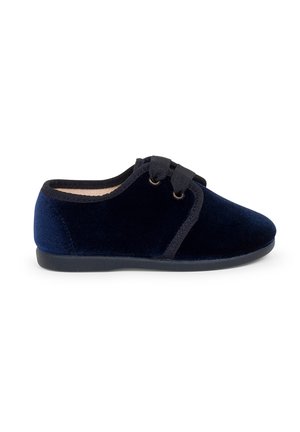 Scarpa in velluto blu navy con punta arrotondata, soletta imbottita e dettagli neri. Presenta un design con lacci e due passanti. Suola in gomma piatta.
