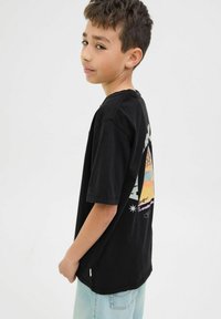 Camiseta de algodón negra con un colorido diseño gráfico en la parte de atrás, mangas cortas, corte relajado y detalle de etiqueta en el costado.