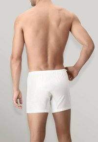 Boxer shorts bianchi con una cintura elastica, realizzati in tessuto liscio, con un design semplice senza motivi o dettagli.