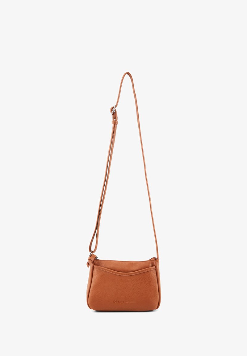 Kleine, beigefarbene Leder-Crossbody-Tasche mit verstellbarem Schulterriemen und vorderer Einschubtasche, minimale Markenkennzeichnung in der Mitte vorne.