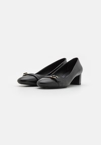Escarpins en cuir noir à talon haut avec un bout arrondi, une sangle décorative et des accents dorés, et un talon bloc moyen. Texture lisse.