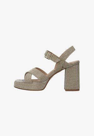 Gouden glitter block-heeled sandalen hebben crisscross banden, een verstelbare enkelgesp en een gestructureerd oppervlak. Vierkante neus en platformontwerp.