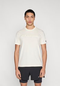 Ανοιχτόχρωμο βαμβακερό t-shirt με στρογγυλή λαιμόκοψη, με ανάγλυφο κείμενο "Champion" στο στήθος και μικρό λογότυπο στο μανίκι.