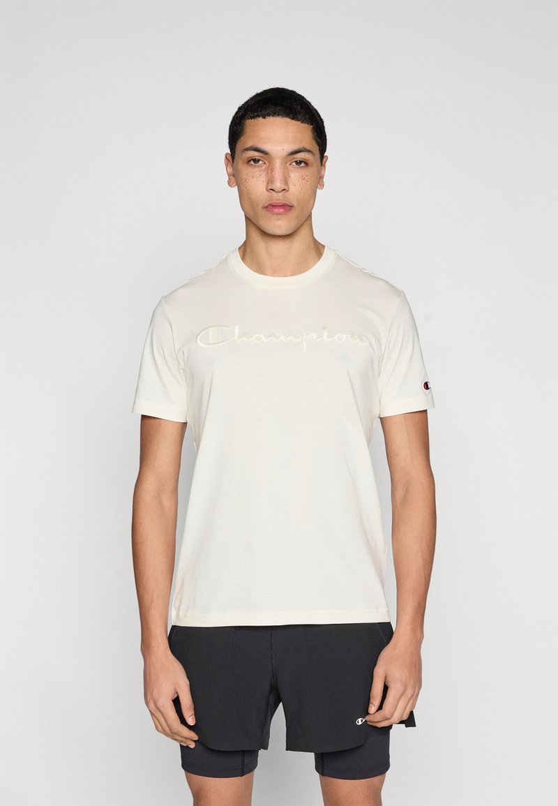 Ανοιχτόχρωμο βαμβακερό t-shirt με στρογγυλή λαιμόκοψη, με ανάγλυφο κείμενο "Champion" στο στήθος και μικρό λογότυπο στο μανίκι.
