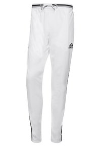 Vita sportbyxor med dragsko i midjan, svarta sidostrickar och en Adidas-logga på nedre benet. Tillverkade av ett slätt, lätt material.