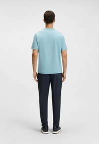 Camiseta de manga corta azul claro combinada con pantalones azul marino oscuros. La camiseta tiene un escote redondo y está hecha de un tejido suave y liviano.