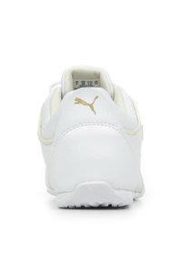 Scarpa sportiva bianca con tomaia in pelle liscia, tacco arrotondato, logo dorato e dettagli texturizzati. Presenta un interno imbottito e suola leggera.