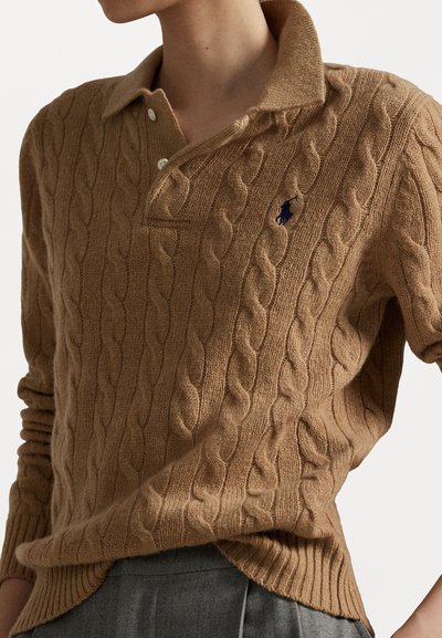 Tan cable-knit sweater with a collared neckline, featuring a classic fit, ribbed cuffs and hem, and a small navy logo on the chest.