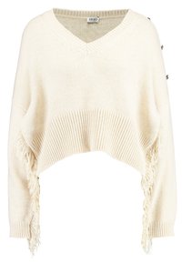 Kremowy, krótkie sweter z dekoltem w kształcie litery V, prążkowaną teksturą oraz frędzlami na dolnym i rękawach. Posiada boczne guziki ozdobne.