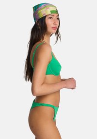 Σετ πράσινο μπικίνι με στήριγμα σουτιέν με λεπτούς ιμάντες και αντίστοιχο σλιπ χαμηλής μέσης. Ομαλό, ελαστικό ύφασμα με ελάχιστες λεπτομέρειες.