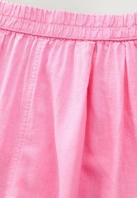Țesătură ușoară, de culoare roz, cu un talie elastică cusută, având o textură subtilă și pliseuri care se drapă. Design simplu, casual pentru fustă.