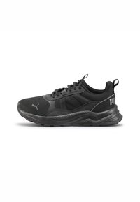 Zapatilla deportiva negra con materiales de malla y sintéticos, punta redondeada, acentos texturizados y detalle del logotipo en el lateral.