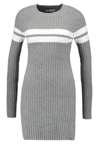 Grå ribbad stickad klänning med lång ärm, med horisontella vita och mörkgrå ränder över bröstet. Rund halsringning.