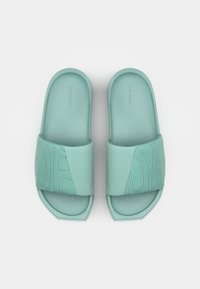 Lys teal slidesandaler med en tekstureret rem med et geometrisk mønster, blødt materiale og en kontureret indersål for komfort.