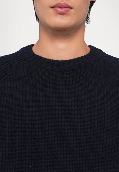 Pulover tricotat ribbed de culoare bleumarin închis, cu guler rotund și material texturat, având umeri puțin lăsați și o finisare netedă.