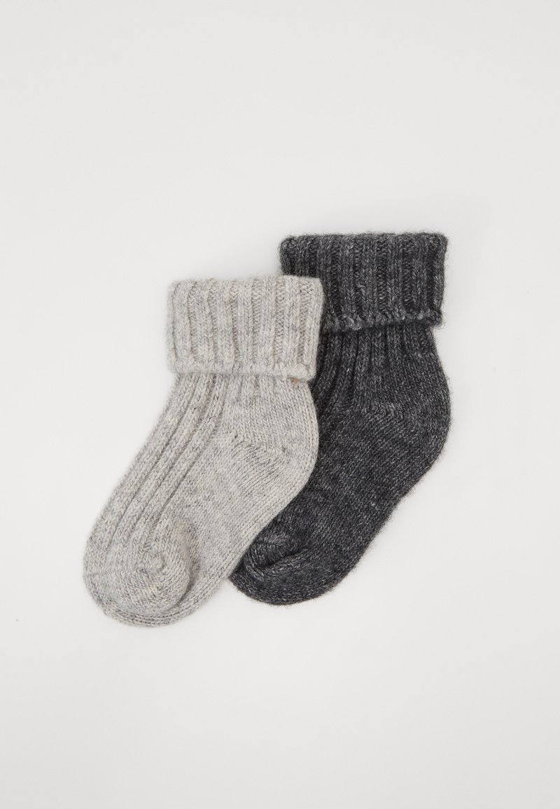 Calcetines de punto en gris y gris claro con puños acanalados, que presentan una textura suave y puntas redondeadas. Están dispuestos uno al lado del otro sobre un fondo blanco.