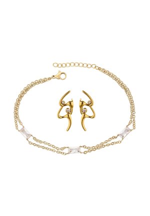 Goudkleurige ketting met laagjes kettingen, drie rechthoekige heldere stenen en bijpassende oorbellen met gebogen ontwerpen en kleine heldere stenen.