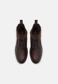 Botas de tobillo de cuero marrón con un acabado suave, diseño con cordones y paneles laterales de ante en contraste. Presentan detalles de cremallera metálica y un interior texturizado.