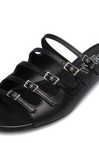 Sandalo in pelle nera con quattro cinturini regolabili e fibbie argentate, design aperto sulla punta e suola liscia e strutturata.