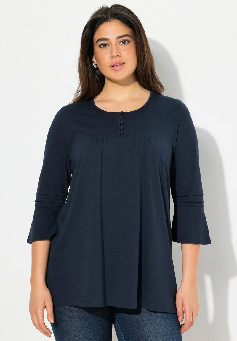 Top blu navy a tre quarti con maniche in tessuto morbido, con parte anteriore plissettata, scollatura rotonda e dettaglio con cinque bottoni al colletto.