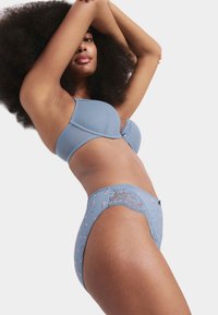 Set di lingerie azzurro chiaro composto da un reggiseno testurizzato e un perizoma a vita alta coordinato, decorato con motivi floreali e dettagli in pizzo.