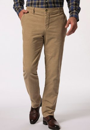 Beige corduroy broek met een rechte pasvorm, voorzien van zijzakken en een enkele knoopsluiting, gecombineerd met donkerbruine leren schoenen.